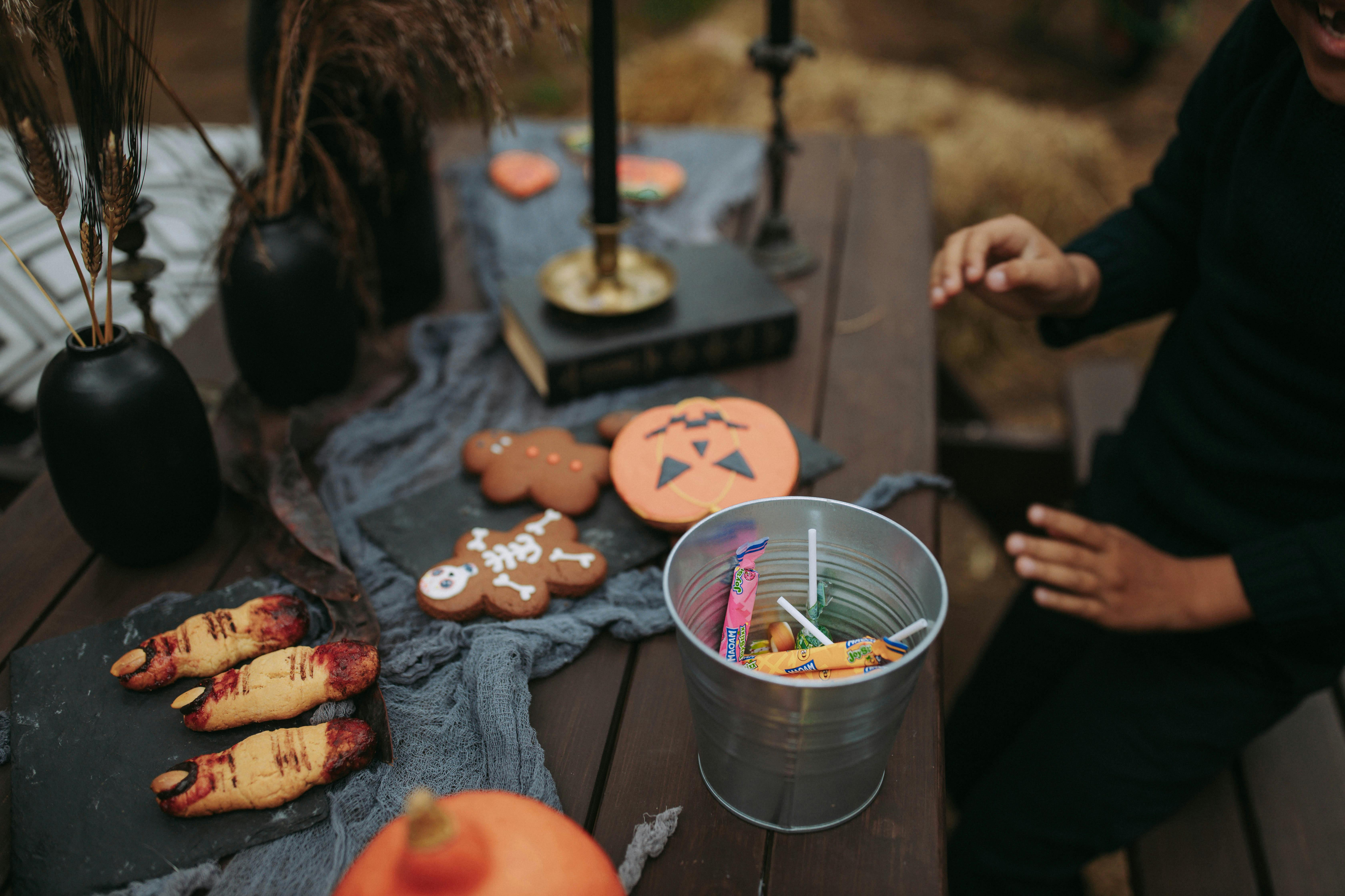 Table of Halloween-themed sweets and cookies for club party celebration